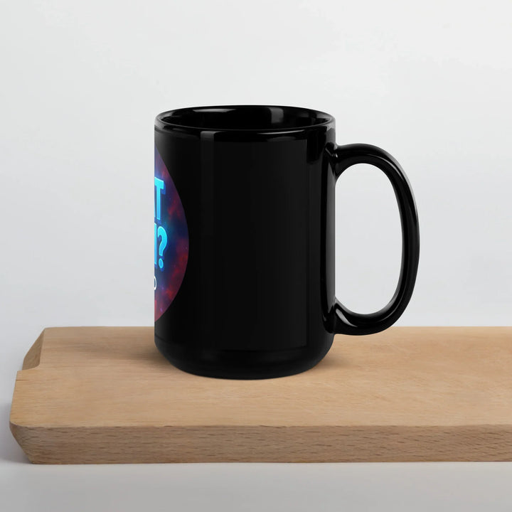 Black glossy What Then Studio mug on wooden board, handle right, partial logo visible