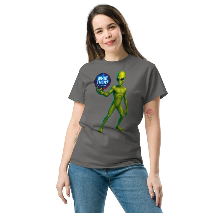 Woman wearing charcoal unisex t-shirt with green alien and What Then? Studio logo graphic