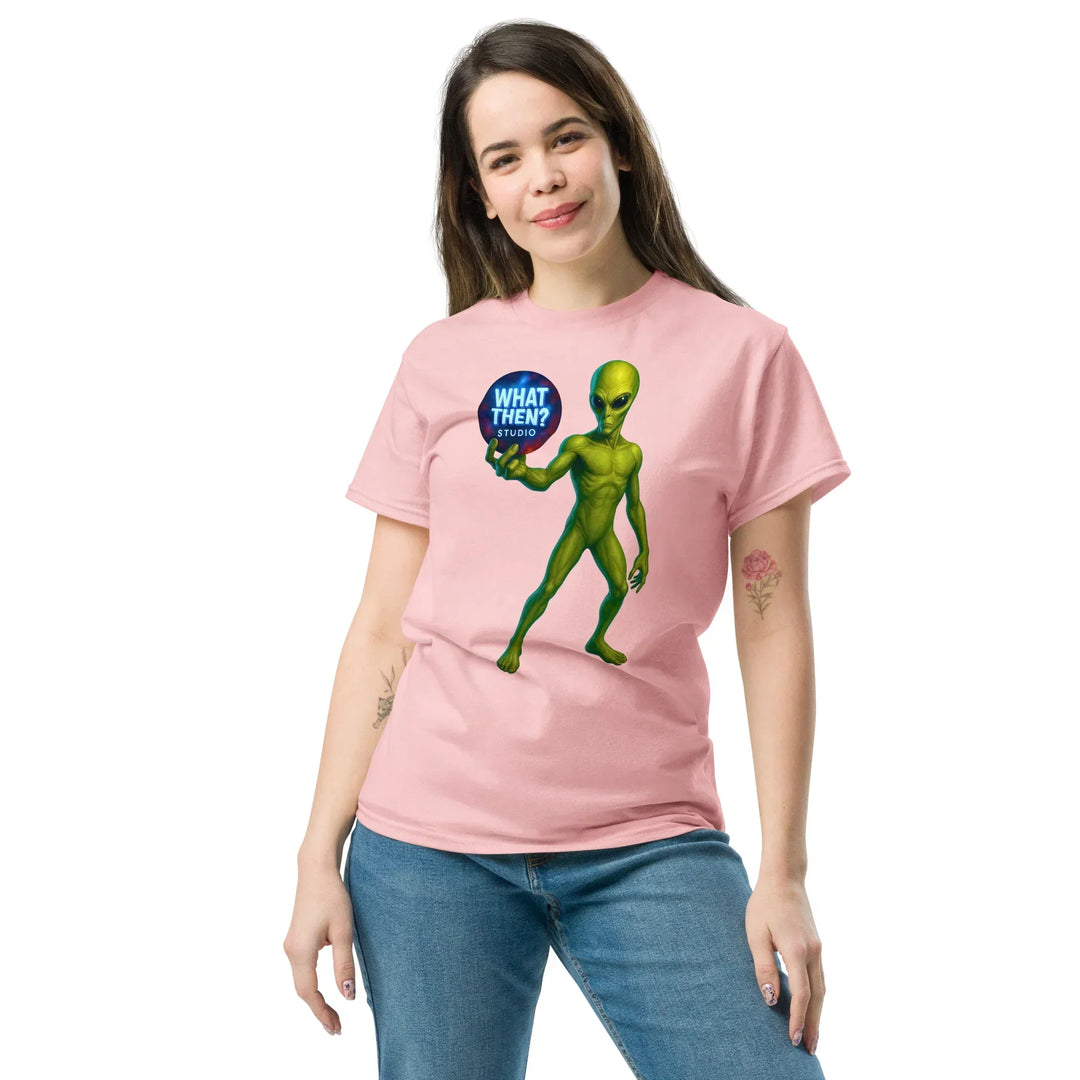 Woman wearing light pink t-shirt with green alien holding 'What Then? Studio' logo print