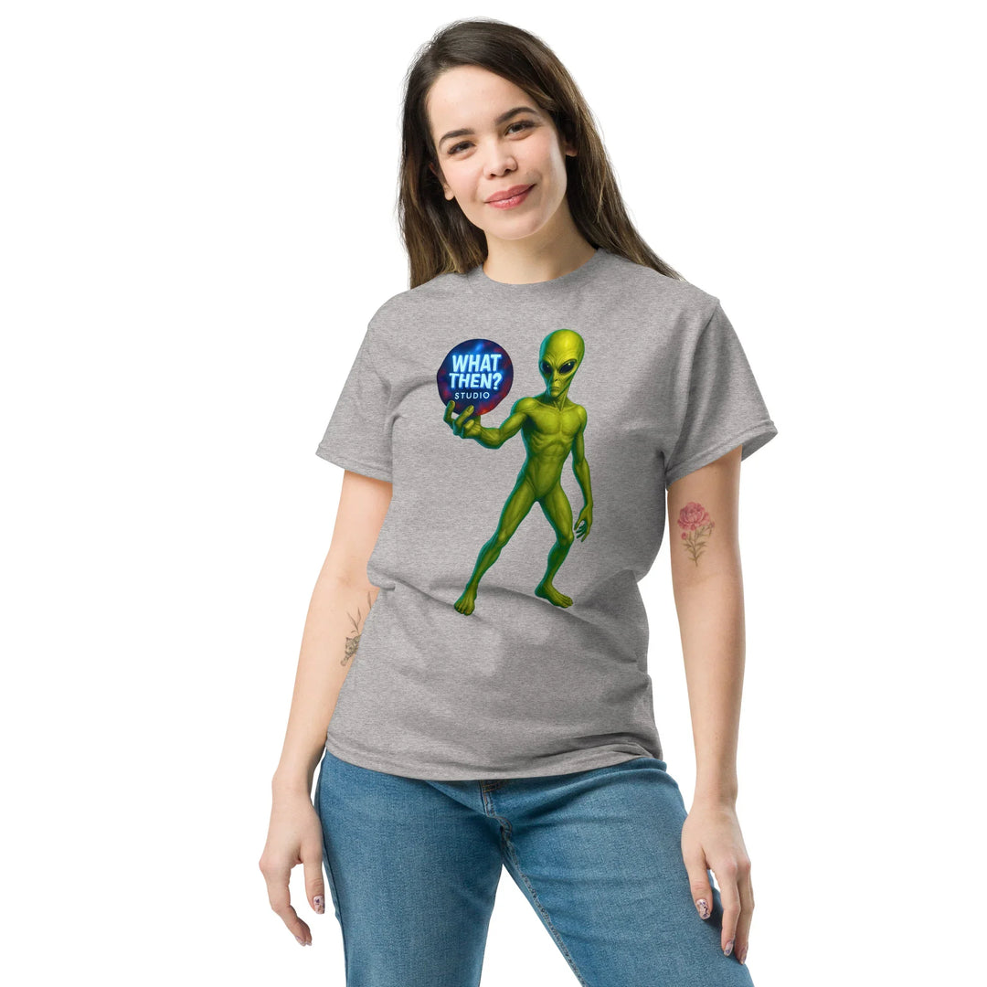 Woman wearing grey What Then Studio t-shirt with green alien graphic and blue logo text.