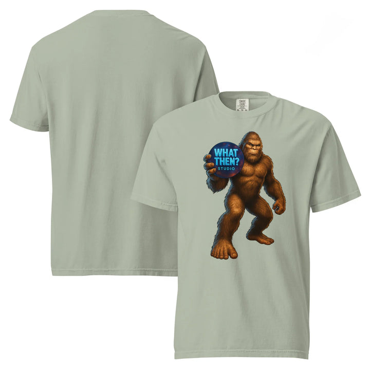 Unisex heavyweight t-shirt in bay color with Bigfoot holding 'What Then? Studio' logo on front