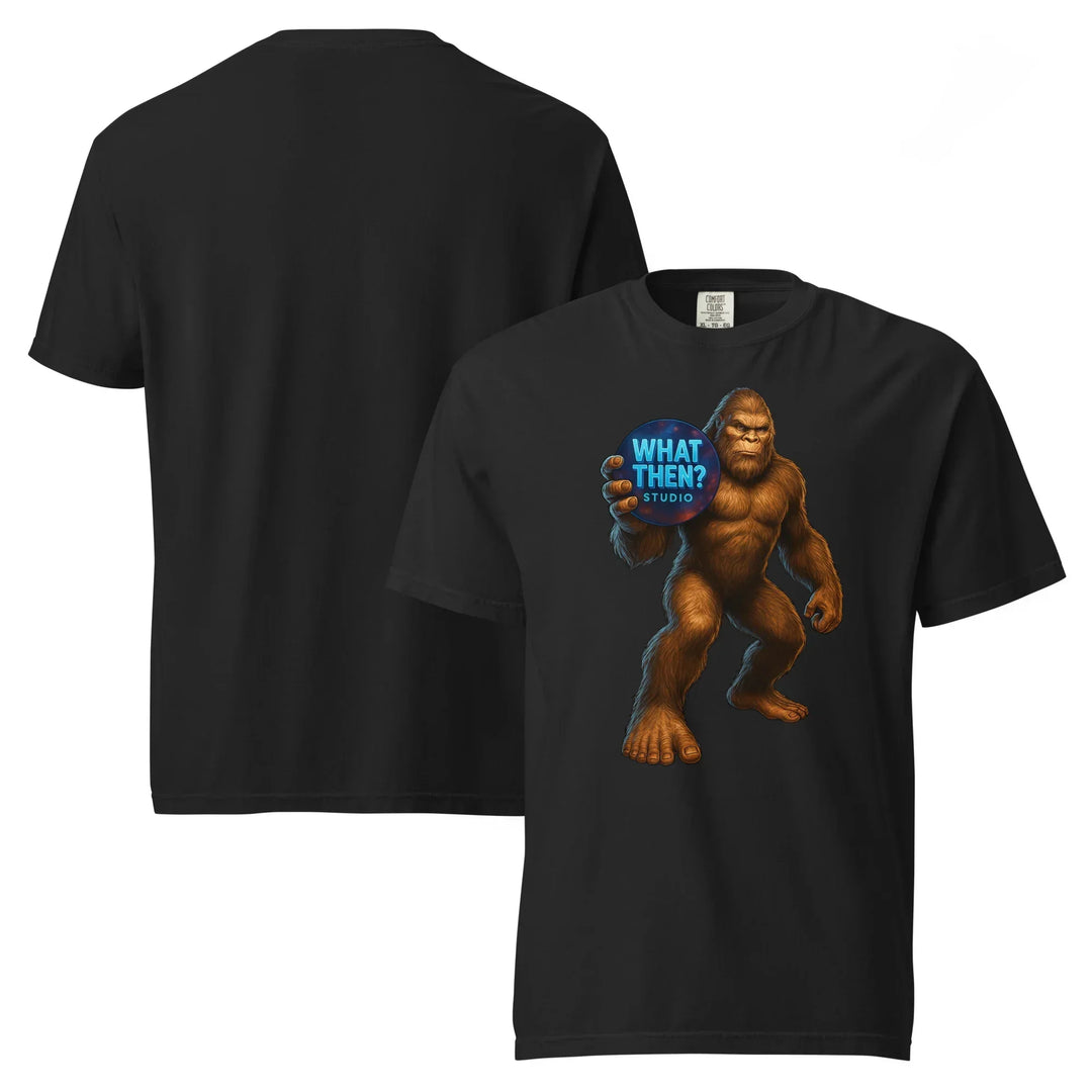 Black heavyweight unisex t-shirt with Bigfoot holding 'What Then? Studio' blue logo on front