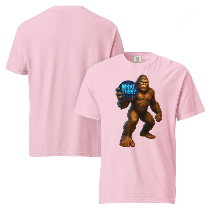 Pink unisex heavyweight t-shirt with Bigfoot holding 'What Then? Studio' graphic on front
