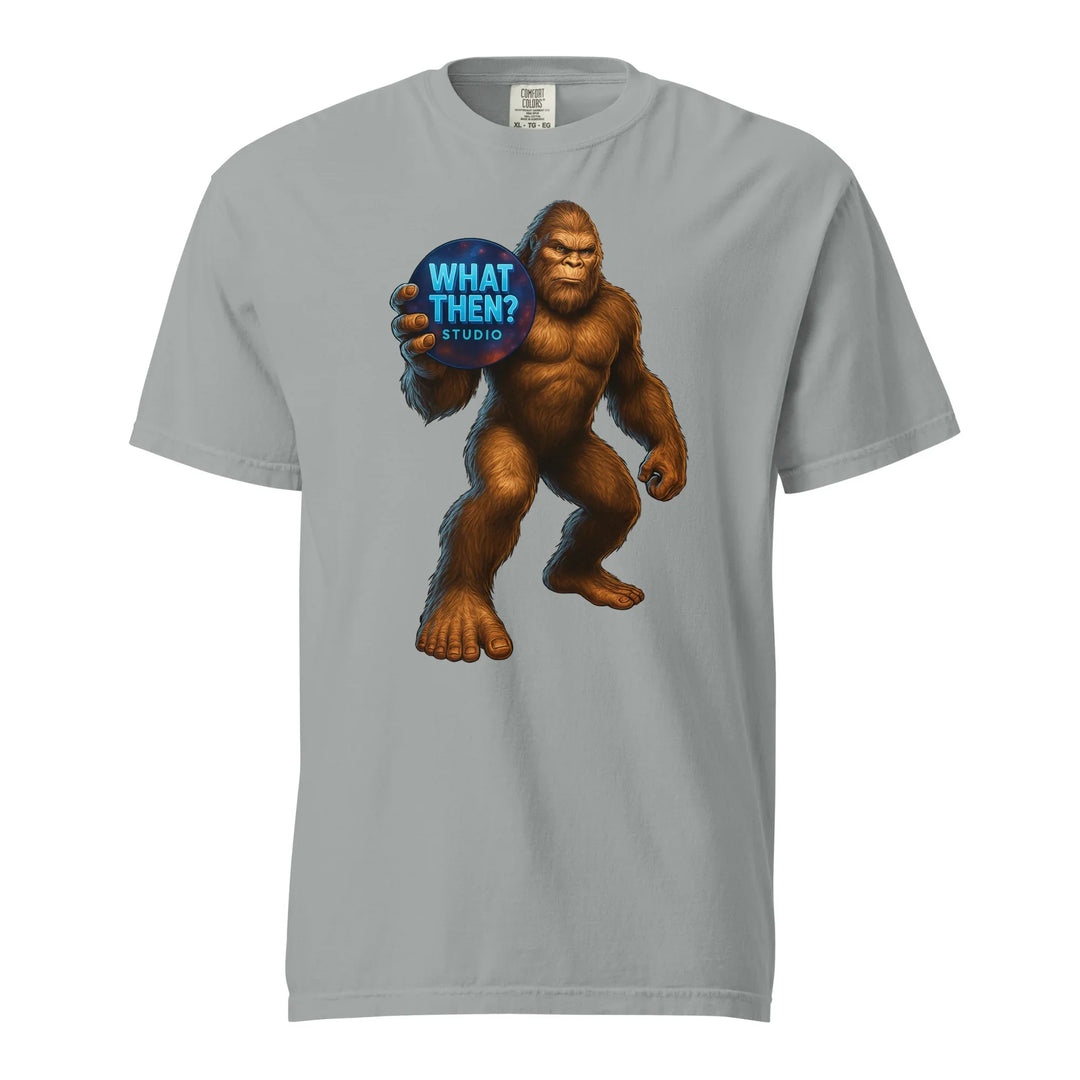 Granite grey unisex t-shirt with Bigfoot holding 'What Then? Studio' sign, paranormal mystery shirt