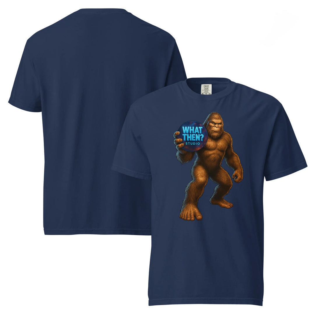Unisex navy heavyweight t-shirt with Bigfoot holding a What Then Studio logo on front
