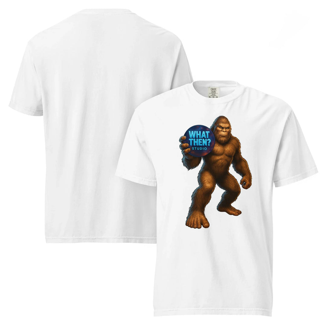 White heavyweight unisex t-shirt with Bigfoot holding 'What Then? Studio' logo on front.