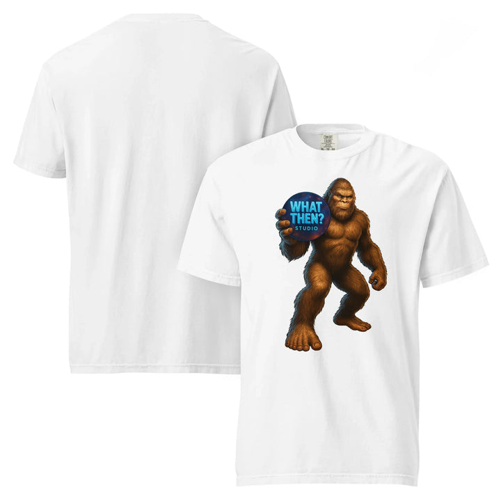 White heavyweight unisex t-shirt with Bigfoot holding 'What Then? Studio' logo on front.